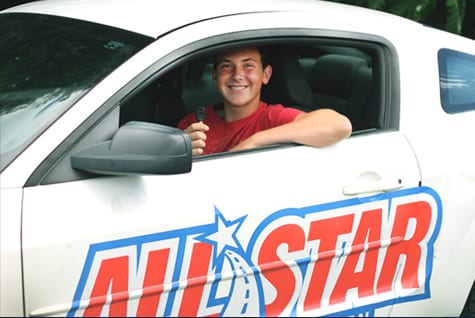 student with car key in all star car smiling